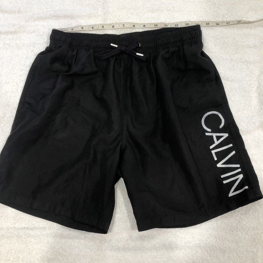 Calvin Klein Swim Shorts Black Medium (Category: Swim Trunks & Board Shorts) located in Manila. Submitted by janmichael26601 (Listing ID 1469206850, Image 1). Description: - Brand: Calvin Klein - Color: Black - Size: Medium (M) - Material: 100% polyester with breathable mesh inner lining - Design: Large vertical CALVIN branding on the left leg - Waistband: Elasticated with adjustable drawstring closure - Pocket: Single back pocket with secure vel