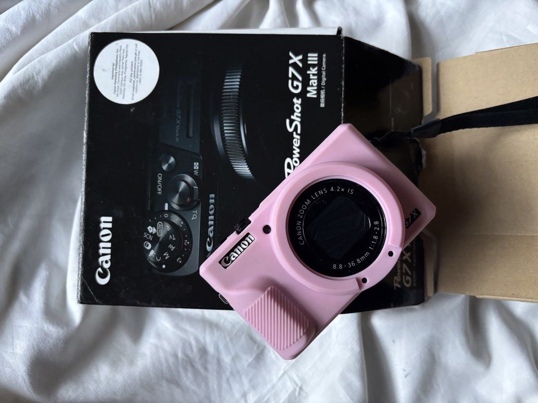 Canon PowerShot G7 X Mark III Digital Camera Pink (Category: Cameras) located in Mandaluyong City. Submitted by mini.declutter (Listing ID 1469385021, Image 1). Description: - Camera Model: Canon PowerShot G7 X Mark III - Condition: Fully operational with a clear live-view LCD screen - Included: Pink silicone protective case and original retail box - Ideal For: Everyday shooting, traveling, and vlogging - Portability: Compact and pocket-sized des