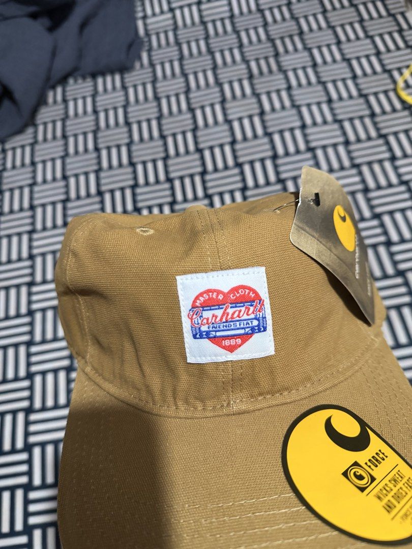 Carhartt WIP Force Cap Brown with Heart Patch (Category: Caps & Hats) located in Manila. Submitted by garcianath68674 (Listing ID 1469285556, Image 2). Description: - Brand new with original tags attached - Color: Classic brown canvas - Rare special edition heart patch logo on the front - Built-in Force sweatband wicks sweat and dries fast - Adjustable strap closure with iconic Carhartt yellow logo tag - One size fits all.