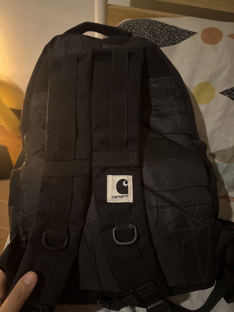 Carthartt Black Backpack with Bungee Cord System (Category: Backpacks) located in Calamba. Submitted by leeadriannn796 (Listing ID 1469313831, Image 2). Description: - Authentic black Carhartt backpack made from heavy-duty canvas - Features adjustable straps and convenient front bungee cord detail - Iconic white Carhartt logo patches on front pocket and shoulder strap - Side mesh pockets for water bottles and easy-access storage - Sturdy zip clos