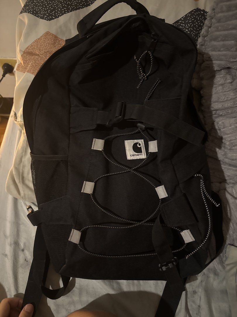 Carthartt Black Backpack with Bungee Cord System (Category: Backpacks) located in Calamba. Submitted by leeadriannn796 (Listing ID 1469313831, Image 1). Description: - Authentic black Carhartt backpack made from heavy-duty canvas - Features adjustable straps and convenient front bungee cord detail - Iconic white Carhartt logo patches on front pocket and shoulder strap - Side mesh pockets for water bottles and easy-access storage - Sturdy zip clos