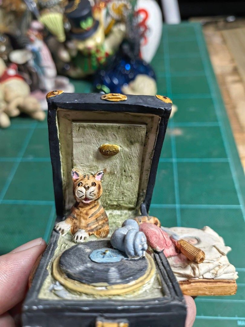 Cat DJ & Gramophone Figurine (Category: Other Home Decor) located in Cebu City. Submitted by dudes_villanueva (Listing ID 1469275418, Image 2). Description: Cat DJ & Gramophone Figurine / Trinket Box In excellent condition -Hand-painted novelty figurine/decor piece featuring a tabby cat sitting inside an open vintage suitcase-style gramophone turntable ​-Detailed miniature scene with a vinyl record, tone arm, and side stack of books/accessories S