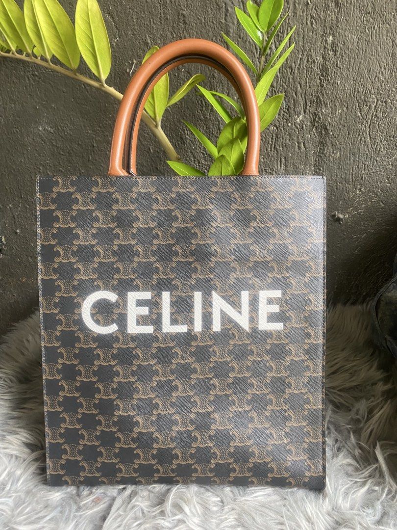 Celine Triomphe Canvas Vertical Cabas Tote Bag (Category: Tote Bags) located in Bacolod City. Submitted by chuchaystuffs (Listing ID 1469167832, Image 1). Description: - Brown and black Triomphe canvas vertical tote with sleek black edge trim - Designed with sturdy tan leather top handles for comfortable carrying - Features a striking white Celine logo printed boldly on the front - Structured rectangular shape with a clean, spacious dark interior