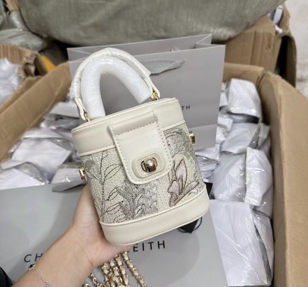 Charles & Keith embroidered bucket bag with chain strap (Category: Cross-body Bags) located in Marikina City. Submitted by ekarengkeng (Listing ID 1469337938, Image 1). Description: - Condition: Brand new, freshly unpacked, and unused - Design: Cream bucket bag with intricate floral embroidery panels - Hardware: Elegant gold-tone hardware with a secure clasp closure - Handles: Structured handle wrapped in protective foam - Straps: Includes a matc