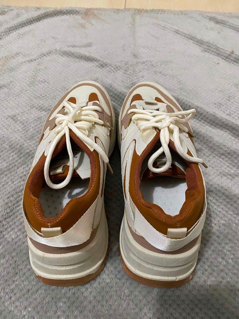 Chunky Platform Sneakers Brown White Size 44 (Category: Sneakers) located in Bacoor. Submitted by rs_finds (Listing ID 1469214233, Image 1). Description: - Color: White, tan, and brown tones - Size: 44 (marked on sole) - Sole: Thick lug soles for extra height and grip - Closure: Front lace-up with white laces - Condition: Clean uppers and fresh soles with hardly any wear on the tread.