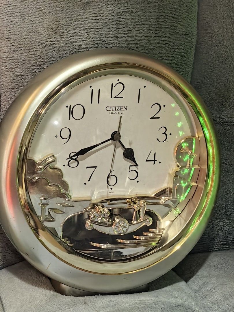Citizen Quartz Round Wall Clock with Moving Gear Design (Category: Clocks) located in Rizal. Submitted by gkstcenit (Listing ID 1469169899, Image 3). Description: Round wall clock made by Citizen Quartz. Silver and gold tone frame with white clock face and black Arabic numerals. Lower section has an intricate moving gear mechanism with metallic sculptural elements including staircases and clouds. Diameter measures roughly 28 centimeters based on 