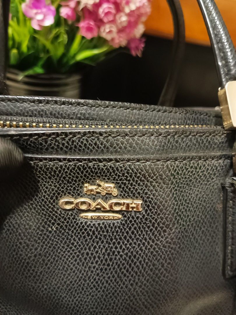 Coach Black Leather Satchel Handbag (Category: Luxury Bags & Wallets) located in Digos. Submitted by chihanu (Listing ID 1469192936, Image 2). Description: - Brand: Coach New York - Material: Black textured leather with gold-tone hardware - Features: Double top handles, detachable shoulder strap, zip-top closure, and convenient magnetic snap compartments - Inclusion: Adorable creature charm attached to the strap - Condition: Good overall, with so