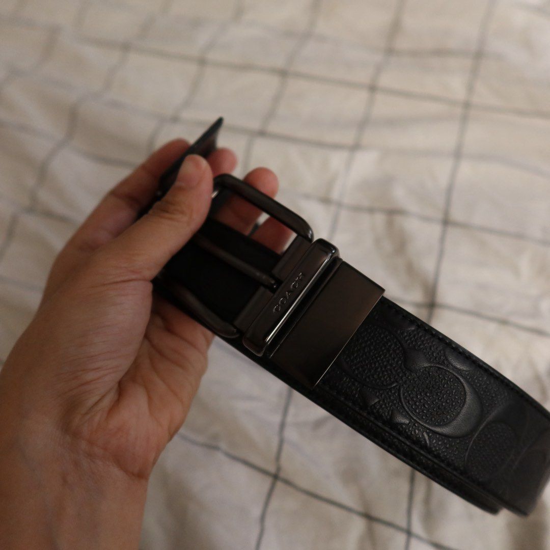 Coach Black Signature Leather Belt (Category: Belts) located in Manila. Submitted by gentlewind_62f064 (Listing ID 1469257801, Image 2). Description: - Brand: Coach - Size: 46in. from buckle - Material: Genuine leather with signature debossed pattern - Hardware: Gunmetal buckle with embossed Coach logo and rotating clasp - Design: Reversible (signature pattern on one side, solid black on the reverse) - Fit: Adjustable sizing with standard punch h