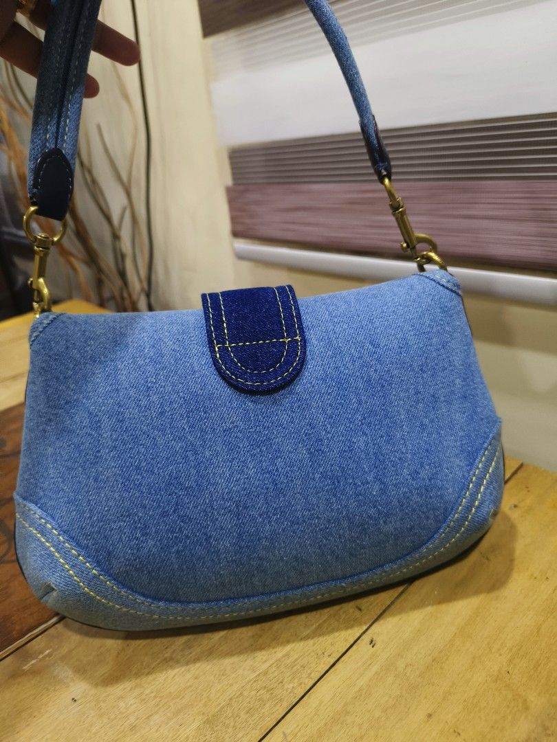 Coach Denim Shoulder Bag Flap Bag (Category: Luxury Bags & Wallets) located in General Santos City (Dadiangas). Submitted by happyrabbit_42489c (Listing ID 1469317138, Image 3). Description: - Coach denim shoulder bag in multi-tone blue denim - Elegant gold-tone hardware and secure front buckle strap closure - Features stylish contrast yellow stitching along the edges and seams - Includes matching detachable denim shoulder strap with lobster clas