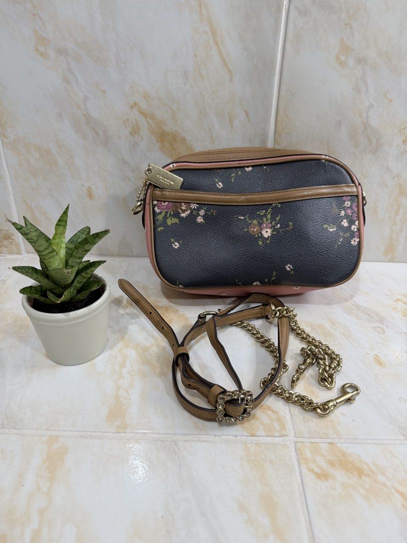 Coach Floral Bow Camera Bag (Category: Luxury Bags & Wallets) located in Manila. Submitted by haveago0dthrift (Listing ID 1469256786, Image 3). Description: - Authentic designer-style black leather camera bag - Eye-catching multicolored floral print with a large front decorative bow - Chic tan leather trim, pink accents, and gold-tone hardware - Versatile styling: comes with an adjustable brown leather strap and a detachable crystal buckle chain 