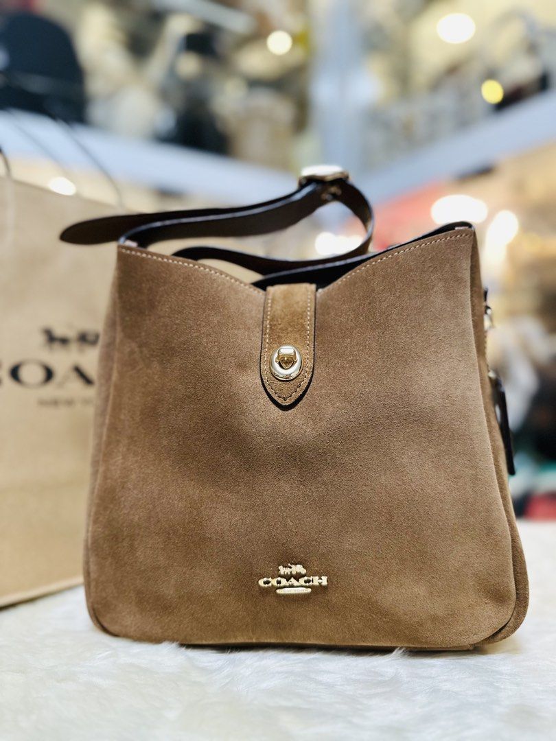 Coach Hadley Brown Suede Shoulder Bag (Category: Luxury Bags & Wallets) located in Porac. Submitted by bagitupshopph (Listing ID 1469162215, Image 2). Description: 💯 Brand new from 🇺🇸 - Material: Rich brown suede with smooth leather lining - Hardware: Gold-tone with front turn-lock closure - Interior: Includes a convenient zip pocket - Included: Extender adjustable shoulder strap so it can be worn as a crossbody bag -Comes with Coach paper sho