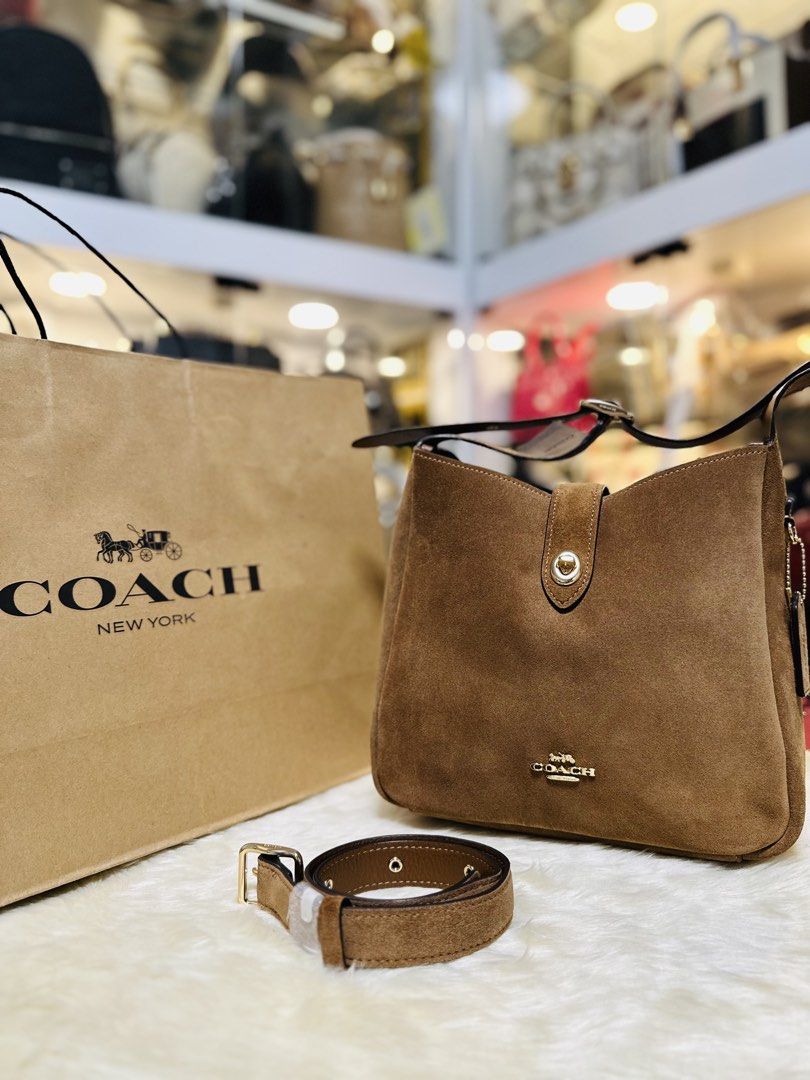 Coach Hadley Brown Suede Shoulder Bag (Category: Luxury Bags & Wallets) located in Porac. Submitted by bagitupshopph (Listing ID 1469162215, Image 1). Description: 💯 Brand new from 🇺🇸 - Material: Rich brown suede with smooth leather lining - Hardware: Gold-tone with front turn-lock closure - Interior: Includes a convenient zip pocket - Included: Extender adjustable shoulder strap so it can be worn as a crossbody bag -Comes with Coach paper sho
