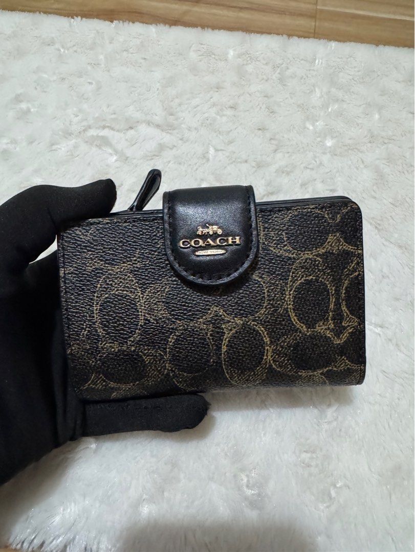 Coach Signature Medium Corner Zip Wallet Black Brown (Category: Wallets & Card holders) located in Carmona. Submitted by outletshopper.ph (Listing ID 1469327649, Image 1). Description: Authentic Coach medium wallet in classic black and brown signature canvas. Features gold-tone hardware, a secure snap closure, multiple card slots, an ID window, a bill compartment, and a back zip coin pocket. Brand new with original tags and plastic wrapping. Perf