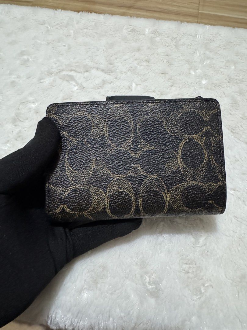 Coach Signature Medium Corner Zip Wallet Black Brown (Category: Wallets & Card holders) located in Carmona. Submitted by outletshopper.ph (Listing ID 1469327649, Image 2). Description: Authentic Coach medium wallet in classic black and brown signature canvas. Features gold-tone hardware, a secure snap closure, multiple card slots, an ID window, a bill compartment, and a back zip coin pocket. Brand new with original tags and plastic wrapping. Perf