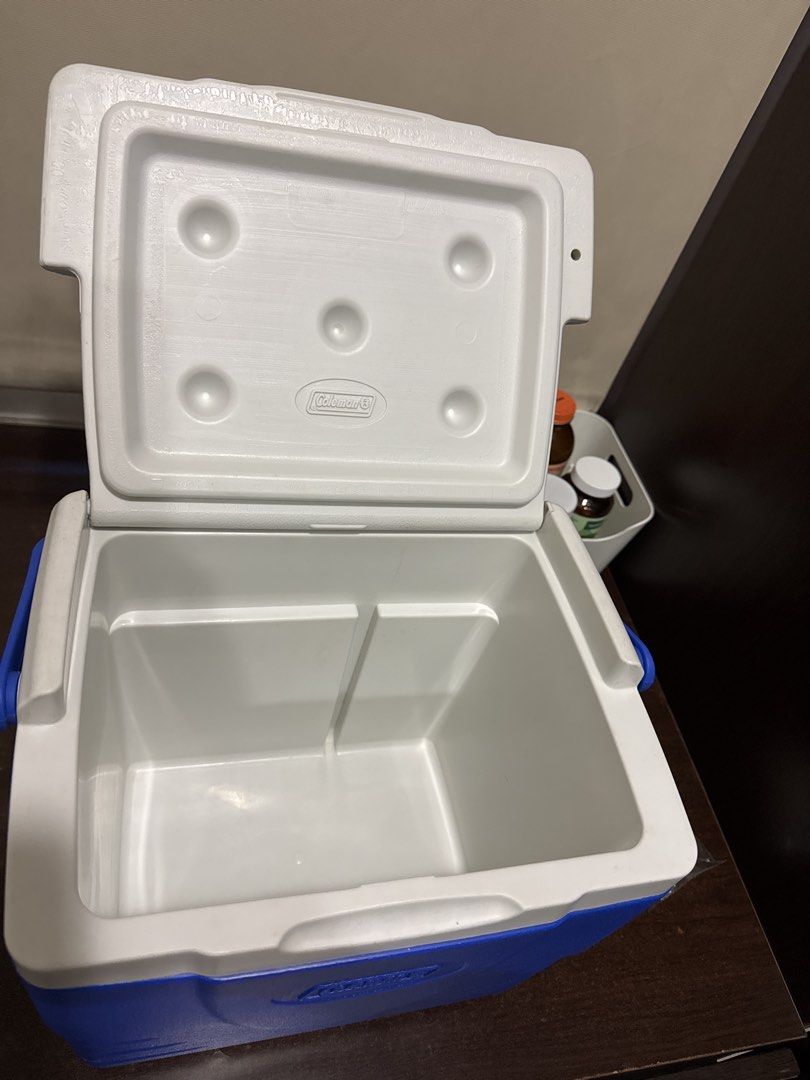 Coleman Blue and White Cooler Box (Category: Food Organization & Storage) located in Quezon City. Submitted by vsaint (Listing ID 1469232469, Image 2). Description: - Authentic Coleman cooler box in classic blue and white - Keeps food and drinks ice-cold for camping, outdoor trips, and beach days - Clean interior with convenient molded cup holders built into the lid - Durable, sturdy plastic construction with an embossed Coleman logo on the front