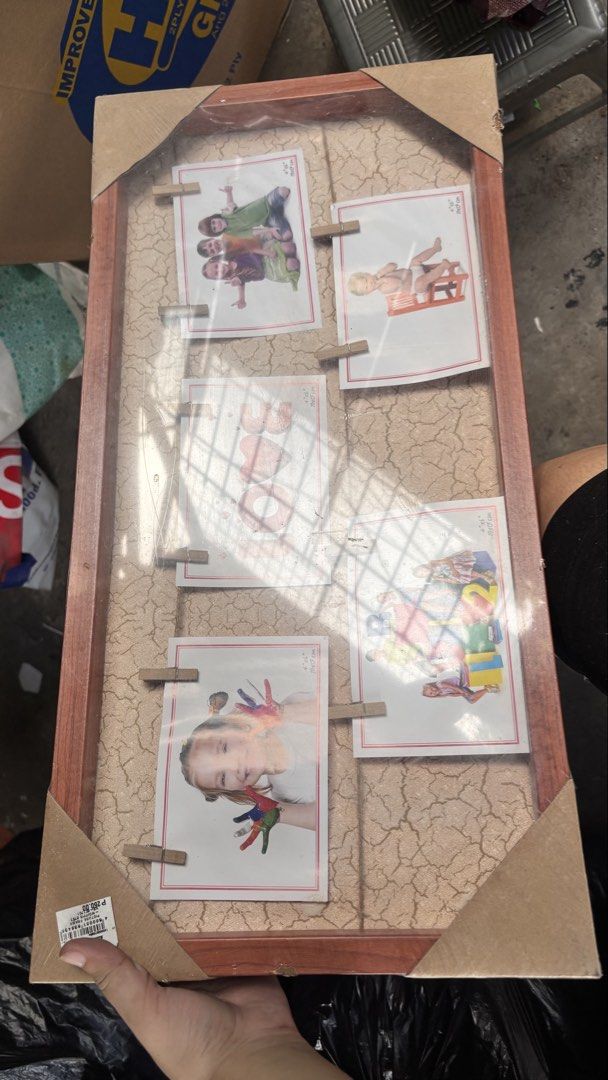 Collage Photo Frame with Clothespins (Category: Frames & Pictures) located in Caloocan City. Submitted by boldcrystal.64c51d (Listing ID 1469230584, Image 2). Description: - Brand new & in original packaging: Still sealed in plastic with corner protectors intact - Holds 5 photos: Perfect for showcasing family memories, baby milestones, or art - Unique design: Wooden frame featuring a stylish crackled texture background - Cute display: Includes mi
