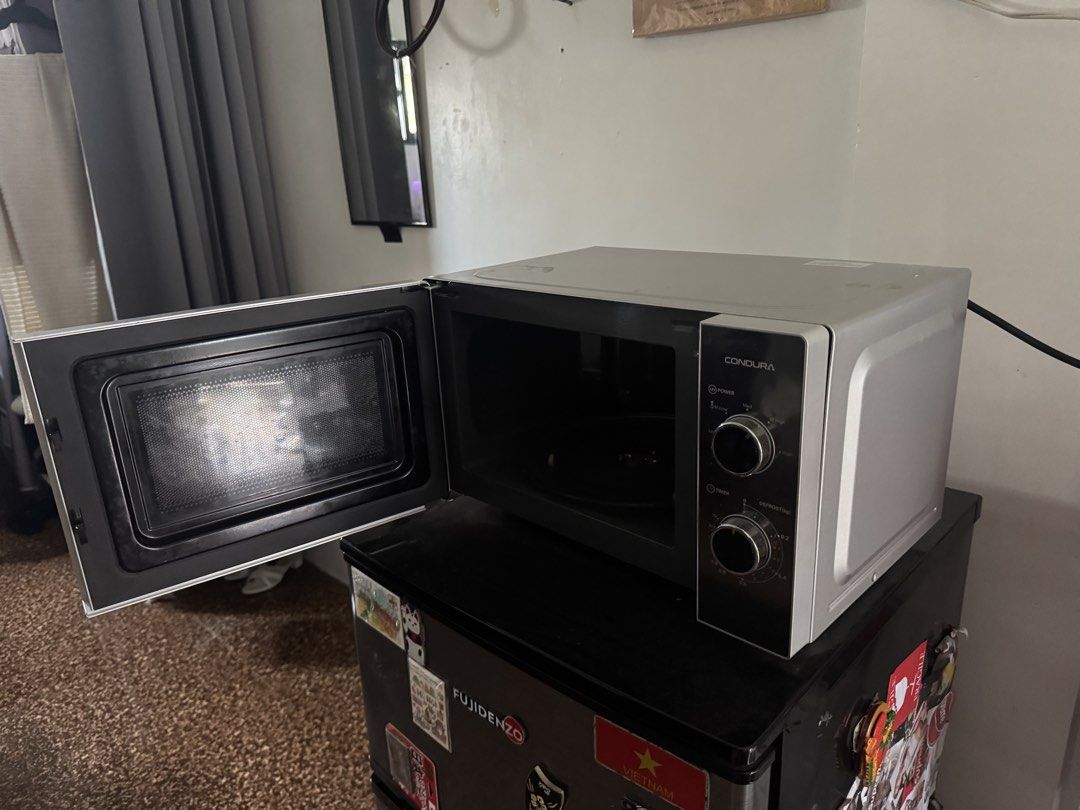 Condura CONMO20.0MMGATELC Microwave (Category: Ovens & Toasters) located in Taguig. Submitted by johnsteven22 (Listing ID 1469215791, Image 3). Description: - Brand/Model: Condura CONMO20.0MMGATELC Microwave Oven - Color/Design: Silver body with a sleek mirror finish door and pull handle - Power: 1,050W for fast heating and defrosting - Controls: Easy mechanical knobs for power and timer - Condition: Clean interior, excellent working condition.