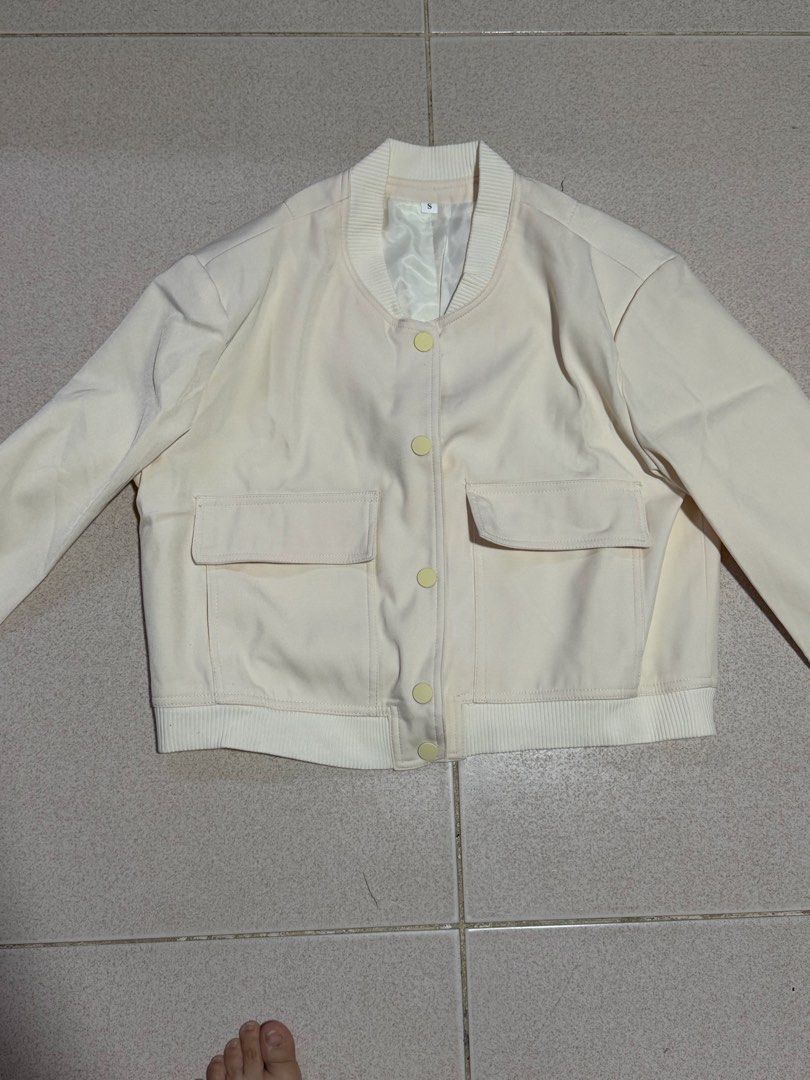 Cream White Bomber Jacket Size S (Category: Coats, Jackets and Outerwear) located in Quezon City. Submitted by wonderrv18 (Listing ID 1469206513, Image 1). Description: - Color: Cream white - Size: Small - Closure: Snap buttons down the front - Details: Ribbed collar and hem, two front flap pockets - Lining: Fully lined interior - Condition: Clean fabric finish, great for layering - Yato bought in tiktok - brandnew.