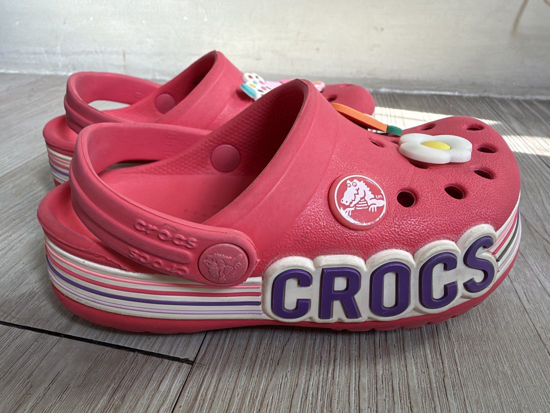Crocs Bayaband Clog with Jibbitz Charms (Category: Babies & Kids Fashion) located in Quezon City. Submitted by warmrabbit_414908 (Listing ID 1469164701, Image 3). Description: - Size: C8 - Features: Bold side lettering and pivoting heel strap - Includes: Fun Jibbitz charms (fried egg, carrot, cupcake, anime character) - Comfort: Iconic Crocs comfort footbed - Condition/Use: Great casual footwear option.