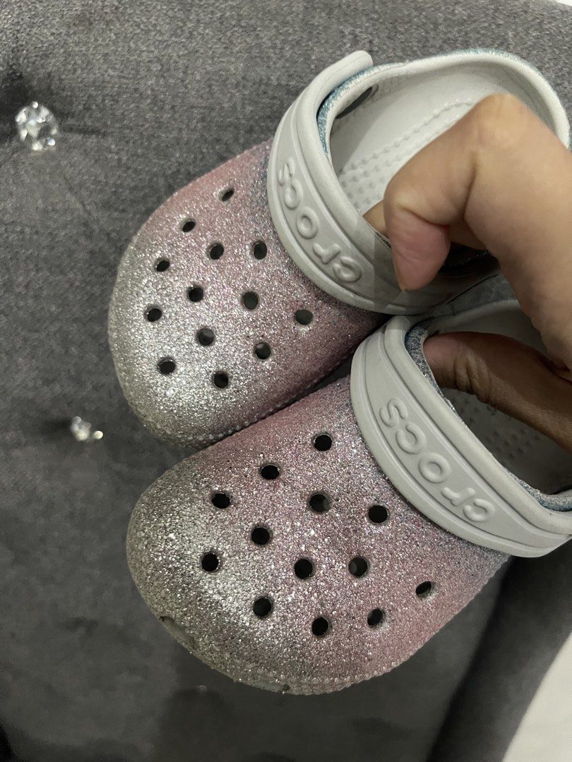 Crocs Classic Glitter Clogs Pink Blue Size C7 (Category: Slippers and slides) located in Lipa City. Submitted by kissesann (Listing ID 1469165648, Image 3). Description: - Item: Pink and blue glitter Crocs clogs with white strap - Size: C7 (molded on sole) - Features: Iconic comfort footbed, slip-on design, ventilation holes on top - Condition: Good, with light signs of wear on the soles - Perfect for daily wear and easy to clean.
