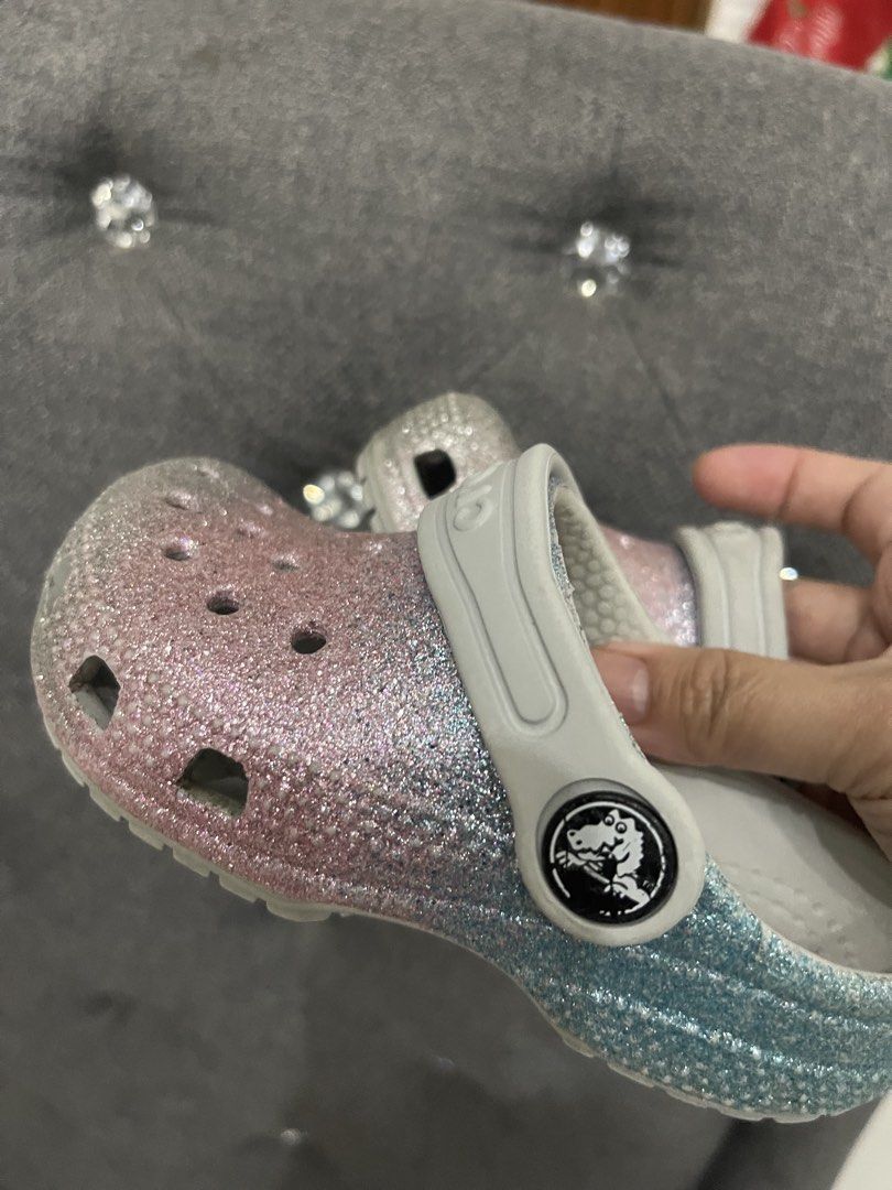 Crocs Classic Glitter Clogs Pink Blue Size C7 (Category: Slippers and slides) located in Lipa City. Submitted by kissesann (Listing ID 1469165648, Image 2). Description: - Item: Pink and blue glitter Crocs clogs with white strap - Size: C7 (molded on sole) - Features: Iconic comfort footbed, slip-on design, ventilation holes on top - Condition: Good, with light signs of wear on the soles - Perfect for daily wear and easy to clean.