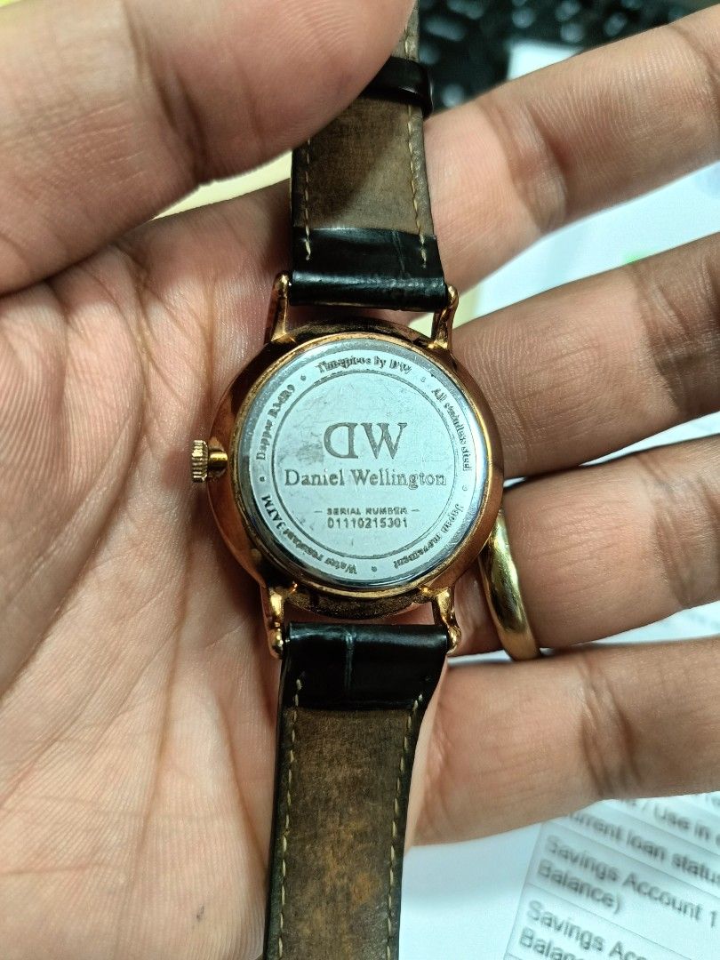 Daniel Wellington Dapper Watch Leather Strap (Category: Men's Watches) located in Panabo. Submitted by markgementiza18 (Listing ID 1469310931, Image 2). Description: 1,300 free shipping - Brand/Model: Daniel Wellington Dapper Watch - Dial: White dial with classic Roman numerals, striking blue hands, and date window - Details: Serial number 0110215301 engraved on back casing - Condition: Normal wear on the leather backing, overall well-maintained.