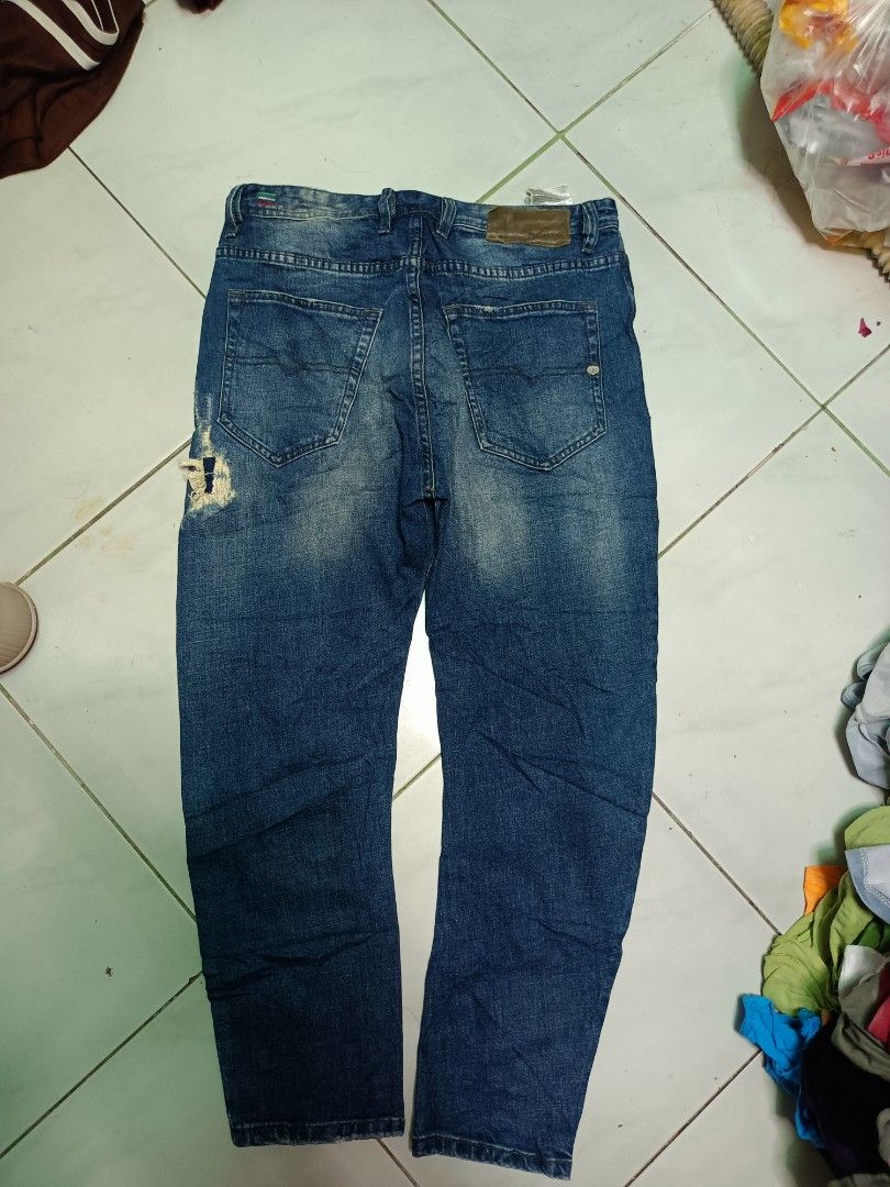 Diesel Co. Distressed Blue Denim Jeans (Category: Jeans) located in Manila. Submitted by pnjdianne25879 (Listing ID 1469211393, Image 2). Description: 32 x 38 exact dimension very excellent condition - Brand: Diesel Co. - Color/Wash: Blue with faded wash and factory distressing - Closure: Button fly - Features: Classic five-pocket styling, intentional wear on back pocket and knee, branded leather back patch, and small coin pocket logo tag - Condi