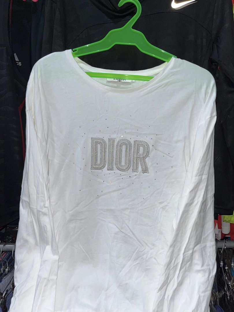 Dior Long Sleeve Crystal Logo Tee (Category: Longsleeves) located in Tabuk. Submitted by collectors_thrift_shop (Listing ID 1469168412, Image 3). Description: - Brand: Dior - Color: White - Size: 13 - Material: Comfortable cotton - Design: Textured Dior lettering on the chest with crystal embellishments and a classic round neckline - Condition: Clean with no major stains or flaws - Style: Great everyday layering piece.