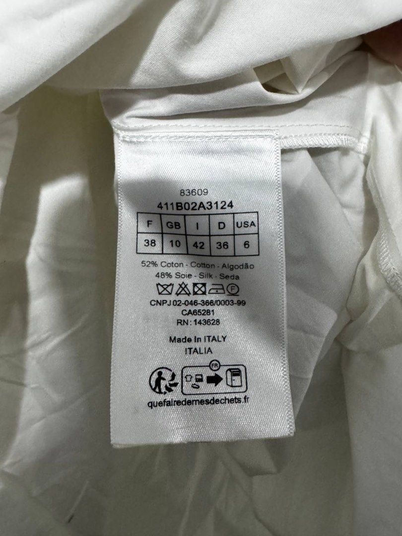 Dior Top (Category: Others Tops) located in Marikina City. Submitted by anndergroundmarket (Listing ID 1469163703, Image 3). Description: White Christian Dior cotton-blend babydoll/huipil blouse or mini dress featuring a small embroidered bee and “CD” logo on the lower front..