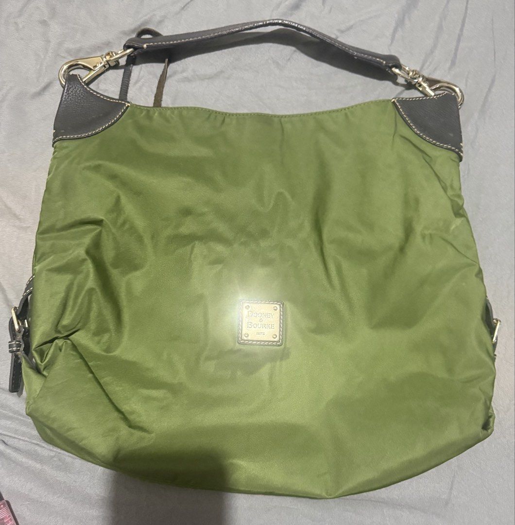 Dooney & Bourke Green Nylon Shoulder Bag (Category: Luxury Bags & Wallets) located in Cainta. Submitted by mykee1 (Listing ID 1469227630, Image 1). Description: - Brand: Dooney & Bourke - Color: Olive green nylon with dark brown leather trim - Hardware: Gold-tone hardware with centered metal logo patch - Strap: Detachable dark brown leather shoulder strap - Design: Spacious, slouchy body with cute gathering details - Condition: Lightweight, clean