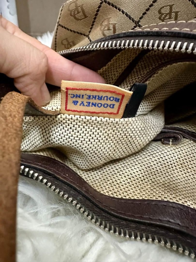 Dooney & Bourke Monogram Shoulder Bag (Category: Luxury Bags & Wallets) located in Santiago. Submitted by evrythngulove (Listing ID 1469334089, Image 2). Description: Authentic Dooney & Bourke shoulder bag in classic beige and brown monogram with dark brown leather trim. Features a top zip closure, clean interior with pockets, and a key keeper strap. Perfect for everyday use!.