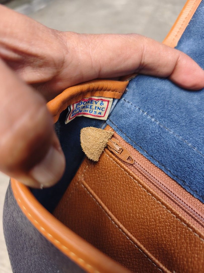 Dooney & Bourke Vintage Leather Saddle Bag (Category: Luxury Bags & Wallets) located in Bulacan. Submitted by THA_D_THRIFT (Listing ID 1469198732, Image 3). Description: - Brand: Dooney & Bourke - Material: Textured leather with suede interior - Color: Dark navy with tan trim - Hardware: Brass - Origin: Made in USA - Closure: Front flap with strap and metal loop - Pockets: 1 interior zippered pocket - Strap: Adjustable shoulder/crossbody strap - 