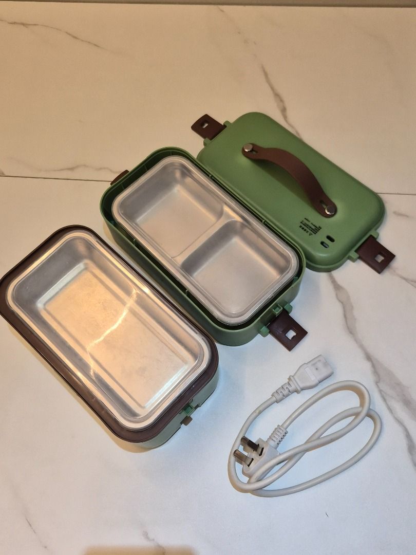 Double-Layer Electric Lunch Box steamer can cook rice (Category: Food Organization & Storage) located in Mandaluyong City. Submitted by buymekatey (Listing ID 1469285685, Image 2). Description: - Color: Green with brown handle and side latches - Material: Stainless steel inner trays - Design: 2 tiers with multi-compartment interior to keep food separate - Usage: Portable electric food warmer for office, school, or travel - Inclusion: Power cord w