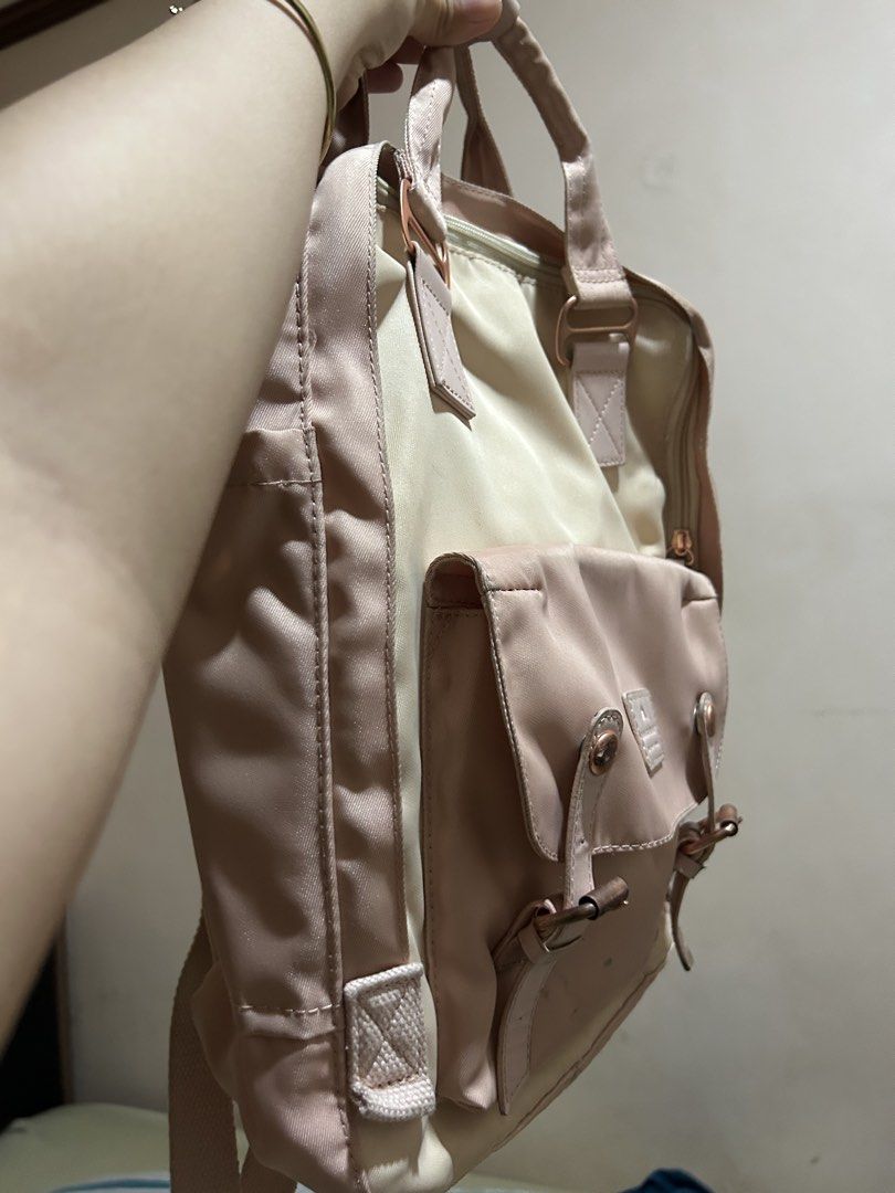 Doughnut Macaroon Backpack Pastel Pink Cream (Category: Backpacks) located in Quezon City. Submitted by temssoleil (Listing ID 1469315344, Image 3). Description: - Brand: Doughnut Macaroon - Used thrice only, there's a little scratch of pen but it can be erased - Colorway: Pastel pink and cream with rose gold hardware - Features: Front pouch pocket with buckle closures, brand patch, adjustable shoulder straps, and top grab handles with snap butto