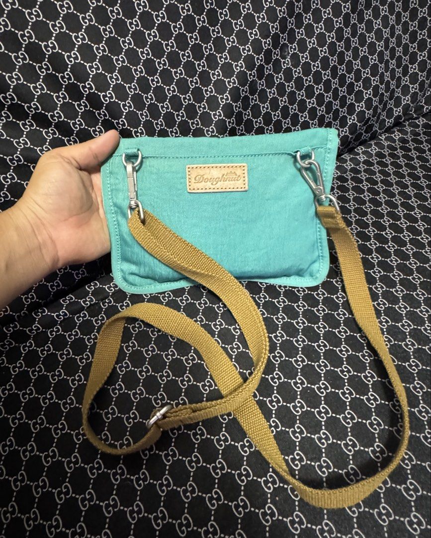 Doughnut Small Teal Adjustable Crossbody Belt Bag (Category: Cross-body Bags) located in Manila. Submitted by esparciake75752 (Listing ID 1469199061, Image 3). Description: - Brand: Doughnut - Color: Teal and yellow with a tan strap - Features: Leather brand patch, snap buttons on back flap, and adjustable strap - Size: Compact, ideal for daily essentials and hands-free convenience - Condition: Clean fabric inside and out, ready for use.