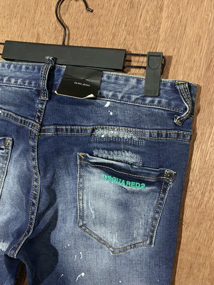 DSQUARED2 Slim Jean Distressed Denim Size 38 (Category: Jeans) located in Tacurong. Submitted by ljsthrift (Listing ID 1469176724, Image 3). Description: - Brand: DSQUARED2 (Made in Italy by Staff International) - Style: Slim fit denim jeans in dark blue wash - Size: 29-30 - Details: Distressed finish with unique paint splatter effects and button fly closure - Signature feature: Green DSQUARED2 embroidery on the back pocket.