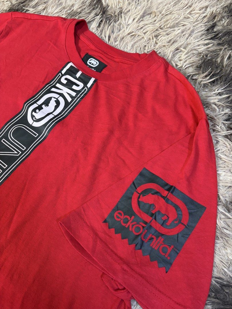 Ecko Unltd. Red T-Shirt Size L (Category: Tshirts & Polo Shirts ) located in Manila. Submitted by _valuevault777 (Listing ID 1469179416, Image 2). Description: - Brand: Ecko Unltd. - Color: Bright red with black and white vertical graphic stripe - Size: L (Large) - Material: 100% cotton, made in China - Details: Features matching branded patches on the left sleeve and bottom hem - Condition: Excellent / Ready to wear.