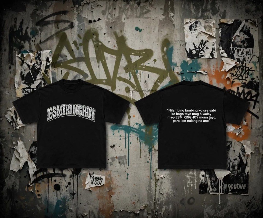 ESMIRINGHOY Black Graphic Tee (Category: Tshirts & Polo Shirts ) located in Quezon City. Submitted by gladysgeron (Listing ID 1469269529, Image 1). Description: - Color: Solid black - Material: Heavyweight cotton fabric - Fit: Relaxed fit with streetwear aesthetic - Design: Bold collegiate text on the chest - Back Print: Funny Tagalog quote in white lettering ("Nilambing lambing ko sya sabi ko bago tayo mag hiwalay mag-ESMIRINGHOY muna tayo, para