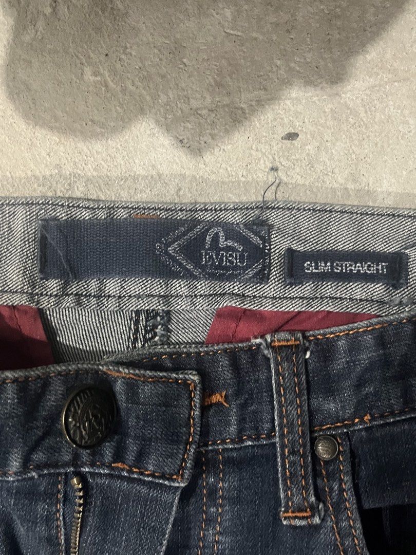 Evisu Beyond The Denim Slim Straight Jeans (Category: Jeans) located in Manila. Submitted by brightriver-55c3 (Listing ID 1469298152, Image 3). Description: - Brand: Evisu - Fit: Slim straight - Color/Wash: Dark wash denim - Details: Yellow 'Beyond The Denim' embroidery on the back - Waistband: Distinct leather patch with metal logo hardware - Closure: Branded button fly - Interior: Red pocket lining - Pockets: Rear welt pockets with contrast tri