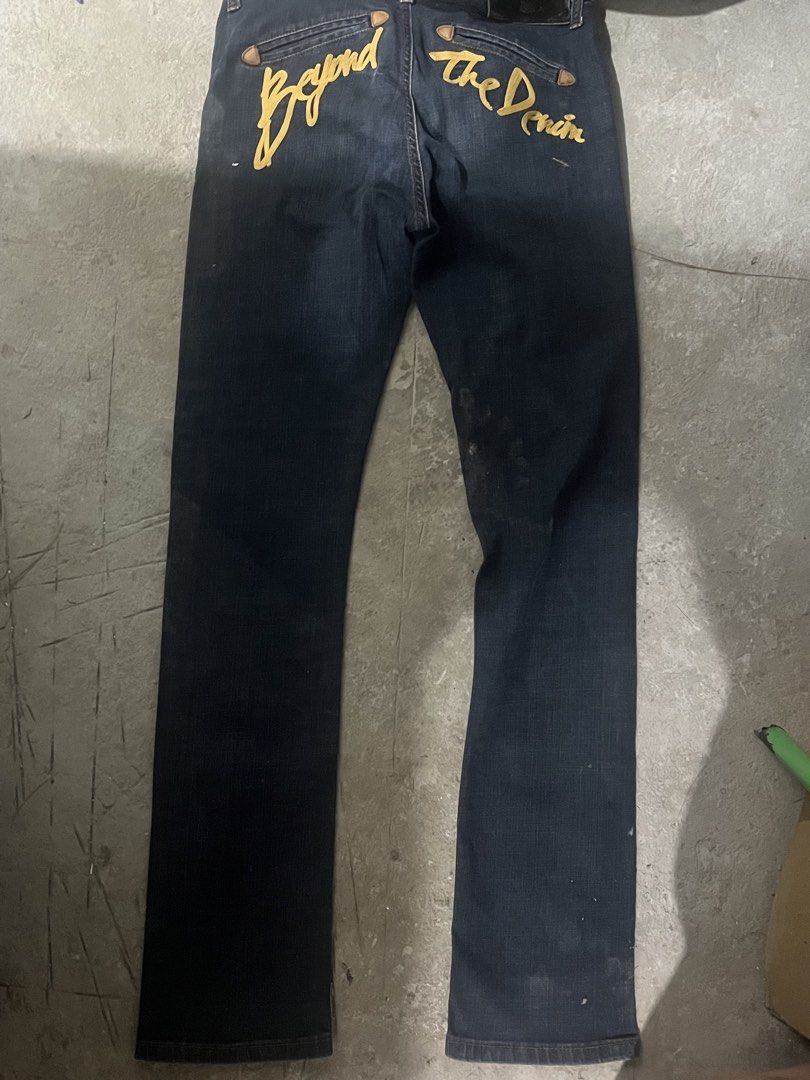 Evisu Beyond The Denim Slim Straight Jeans (Category: Jeans) located in Manila. Submitted by brightriver-55c3 (Listing ID 1469298152, Image 2). Description: - Brand: Evisu - Fit: Slim straight - Color/Wash: Dark wash denim - Details: Yellow 'Beyond The Denim' embroidery on the back - Waistband: Distinct leather patch with metal logo hardware - Closure: Branded button fly - Interior: Red pocket lining - Pockets: Rear welt pockets with contrast tri