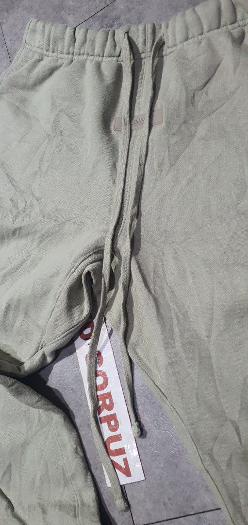 Fear of God Essentials Sweatpants (Category: Joggers) located in Laoag. Submitted by floydg_corpuz22 (Listing ID 1469227098, Image 3). Description: Fear of God Essentials sweatpants in light sage green, size S. Features an adjustable drawstring waist, signature rubberized logo, bold left leg print, and cozy fleece lining. Perfect for everyday streetwear. Essentials Small 30 to 34 x 37.5 Excellent condition 650+sf.