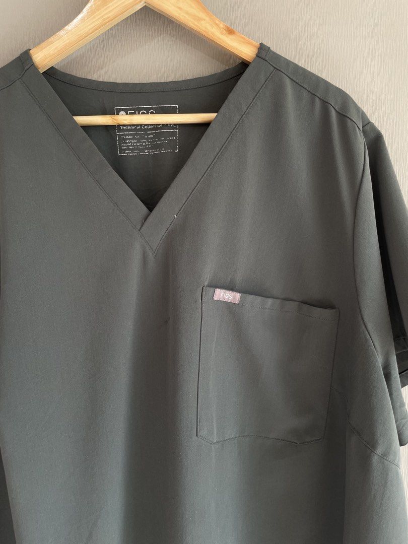 FIGS Catarina Scrub Top Dark Grey (Category: Activewear) located in Mataasnakahoy. Submitted by zero4thrift (Listing ID 1469217054, Image 2). Description: - Brand: FIGS - Style: Catarina (V-neck, short sleeves) - Color: Dark Grey - Details: Single chest pocket with FIGS logo label - Material: 72% polyester, 21% rayon, 7% spandex - Care: Machine washable - Condition: Excellent pre-loved / Like new - Perfect for healthcare professionals looking for