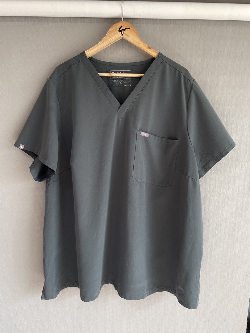 FIGS Catarina Scrub Top Dark Grey (Category: Activewear) located in Mataasnakahoy. Submitted by zero4thrift (Listing ID 1469217054, Image 1). Description: - Brand: FIGS - Style: Catarina (V-neck, short sleeves) - Color: Dark Grey - Details: Single chest pocket with FIGS logo label - Material: 72% polyester, 21% rayon, 7% spandex - Care: Machine washable - Condition: Excellent pre-loved / Like new - Perfect for healthcare professionals looking for