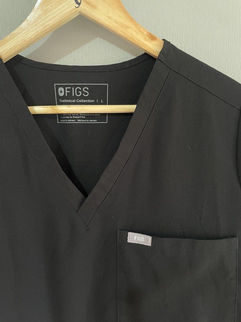 FIGS Technical Collection Black Scrub Top Size L (Category: Activewear) located in Mataasnakahoy. Submitted by zero4thrift (Listing ID 1469207804, Image 2). Description: - Brand: FIGS (Technical Collection) - Color: Black - Size: Large (Style: FW1000) - Material: 72% polyester, 21% viscose, 7% elastane (stretch fabric) - Features: V-neck, chest pocket with FIGS logo tag, small logo on right sleeve - Condition: Clean, EUC, ready to wear FIGS Catar