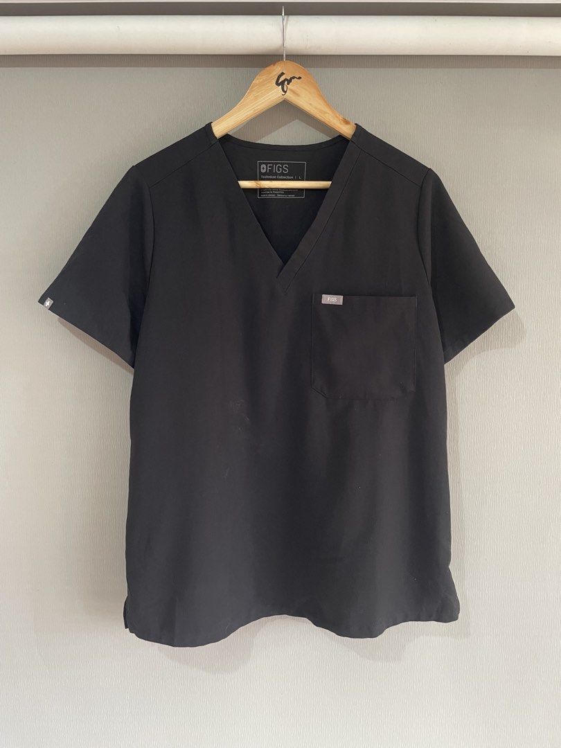 FIGS Technical Collection Black Scrub Top Size L (Category: Activewear) located in Mataasnakahoy. Submitted by zero4thrift (Listing ID 1469207804, Image 1). Description: - Brand: FIGS (Technical Collection) - Color: Black - Size: Large (Style: FW1000) - Material: 72% polyester, 21% viscose, 7% elastane (stretch fabric) - Features: V-neck, chest pocket with FIGS logo tag, small logo on right sleeve - Condition: Clean, EUC, ready to wear FIGS Catar