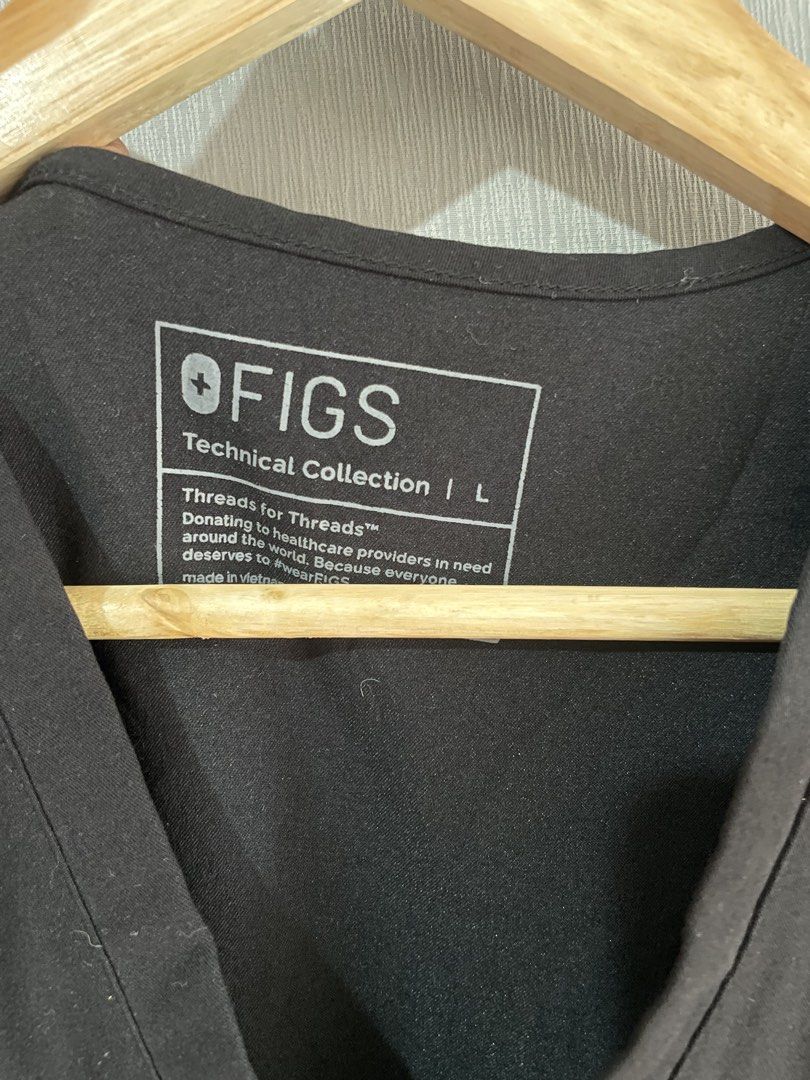 FIGS Technical Collection Black Scrub Top Size L (Category: Activewear) located in Mataasnakahoy. Submitted by zero4thrift (Listing ID 1469207804, Image 3). Description: - Brand: FIGS (Technical Collection) - Color: Black - Size: Large (Style: FW1000) - Material: 72% polyester, 21% viscose, 7% elastane (stretch fabric) - Features: V-neck, chest pocket with FIGS logo tag, small logo on right sleeve - Condition: Clean, EUC, ready to wear FIGS Catar
