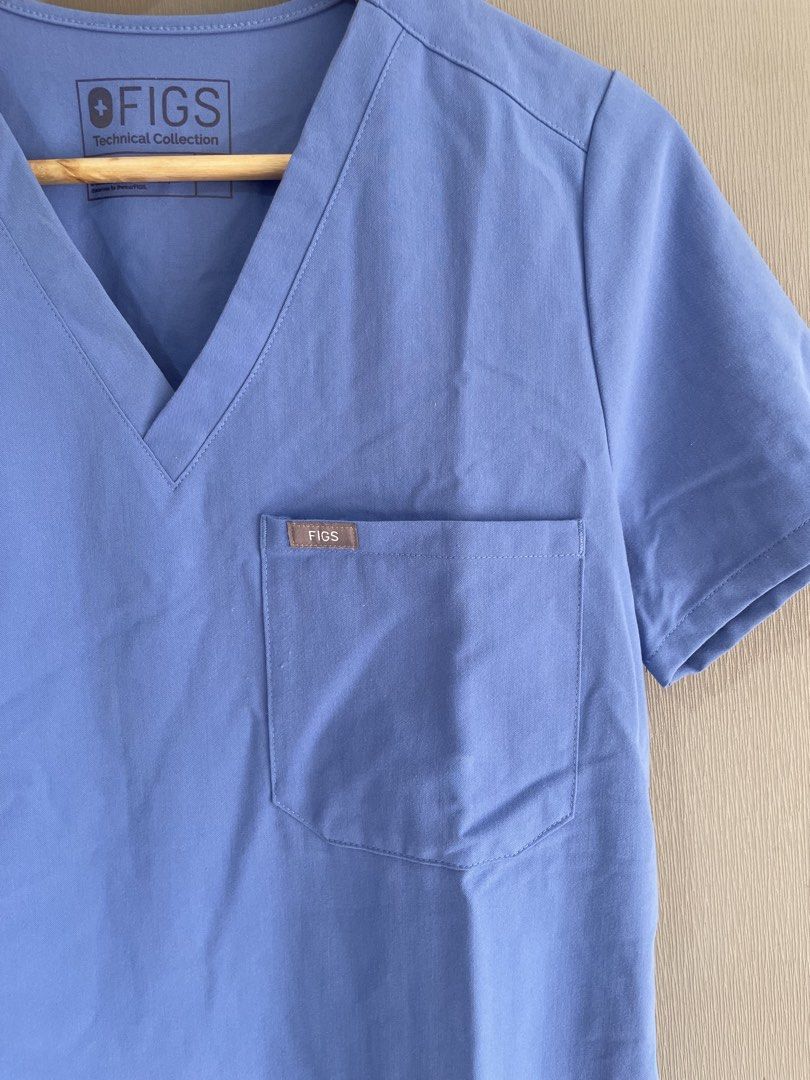 FIGS Technical Collection Blue Scrub Top Size S (Category: Activewear) located in Mataasnakahoy. Submitted by zero4thrift (Listing ID 1469203485, Image 3). Description: - Brand: FIGS (Technical Collection) - Style: Classic V-neck with single chest pocket & logo - Color: Bright Blue - Size: Small - Material: 72% polyester, 21% rayon, 7% spandex - Condition: Clean, minimal signs of wear FIGS Catarina One-Pocket Scrub Top (Ceil Blue) Small on tag 19