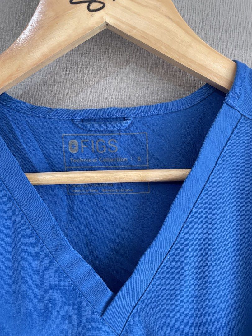 FIGS Technical Collection Scrub Top Royal Blue Size S (Category: Activewear) located in Mataasnakahoy. Submitted by zero4thrift (Listing ID 1469211971, Image 2). Description: - Brand/Collection: FIGS Technical Collection - Style Number: W22SW1014 - Color: Vibrant Royal Blue - Size: Small - Material: 72% Polyester, 21% Rayon, 7% Spandex - Features: Classic V-neck, single chest pocket with logo label, signature cross logo on the right sleeve - Cond
