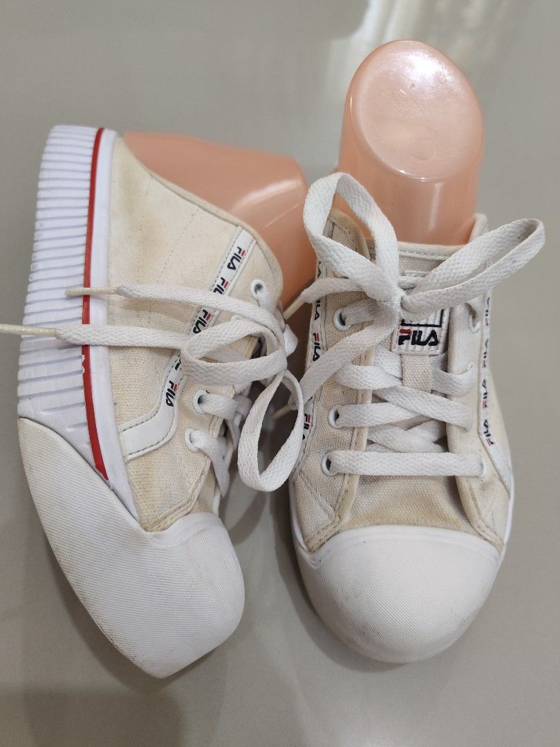 Fila White Platform Sneakers (Category: Sneakers) located in Calamba. Submitted by an_ne0501 (Listing ID 1469215049, Image 1). Description: - Brand: Fila - Style: Canvas platform sneakers with chunky wavy soles - Color: White with red trim detailing - Closure: Lace-up with signature Fila branding on the tongue and side - Condition: Pre-loved, featuring noticeable discoloration/staining on the white canvas and moderate dirt accumulation on the rub