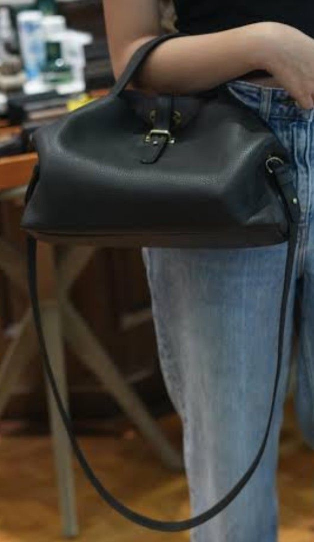 Fino Leatherware Black Pebble Leather Handbag (Category: Luxury Bags & Wallets) located in Valenzuela. Submitted by ryu12 (Listing ID 1469209242, Image 2). Description: - Brand: Fino Leatherware - Material: Premium black pebbled leather with silver-tone hardware - Design: Structured shape with strap buckle closure and brand plaque on base - Versatility: Includes double top handles and a detachable long shoulder strap - Functionality: Roomy interi